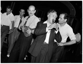 [Men performing a folk dance.]