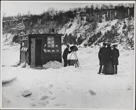 [Photographer taking a portrait outside of a tintypes booth in the snow]