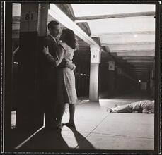 Life and Love on the New York City Subway [Couple on the 81st Street subway platform by a sleeping man.]