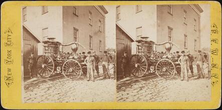 [Firemen with early fire engine.]