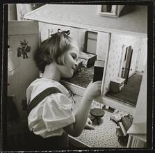 Orphanage [Girl playing with a dollhouse.]