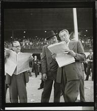 Aqueduct Race Track [Men reading newspapers at a racetrack.]