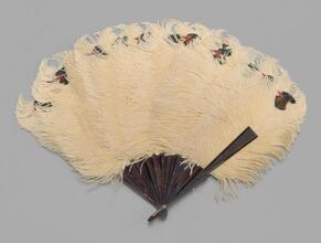 Folding feathered fan of yellow ostrich feathers tipped with birds' heads