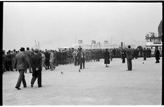 [People waiting on the dock of the Hoboken Ferry Terminal.]