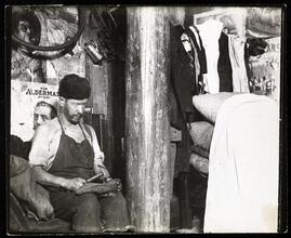 Shoemaker working in a house in the yard of 219 Broome Street, which the landlord built when the sanitary police put him out of the basement. Clatterpole sticks up through his house. Rent $12 a month.
