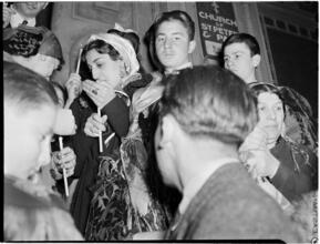 [Worshippers with candles at a Greek Orthodox church service.]