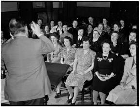 [Man talking to an audience of women.]