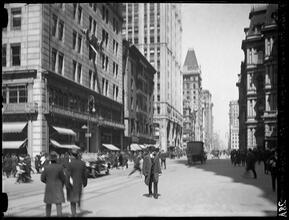 Broadway Series. Looking north from Vesey Street showing west side of Bway. Astor Building, and Old Astor Hotel on left, then Woolworth Building. Corner of post office shows at right. Street level vie