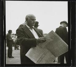 Aqueduct Race Track [Man reading newspapers and racing forms.]