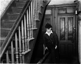 Teenager Sitting on a Banister in the Hallway