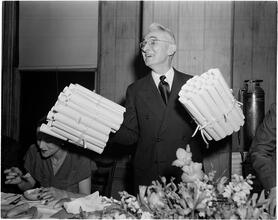 Dale Carnegie [Dale Carnegie holding diplomas.]