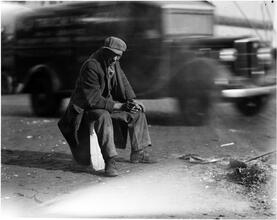 Waterfront. [Man seated on the street.]