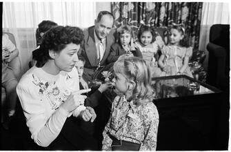 Deaf Children [Teacher helping child with her hearing aid.]