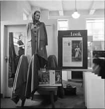 Bloomingdale's [Display in Bloomingdale's featuring a mannequin with a coat and "As Seen in LOOK Magazine" posters surrounding the display.]