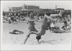 [Teenage boys performing stunt at Coney Island beach.]