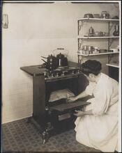 [Gas range with woman cooking.]