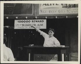[Sideshow talker pointing to sign advertising Elma Von Lynd, the 3 Legged Girl.]