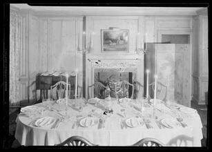 Carroll Carstairs [residence]. Dining room table set with candles lighted, light effect.