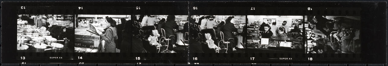 The 5 and 10 [Women shopping and child in a stroller at the lunch counter in Woolworth's.]