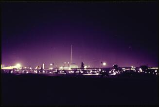 [Fairgrounds at dusk, looking toward the Trylon and Perisphere.]