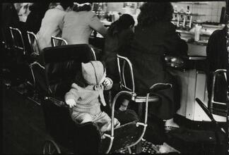 The 5 and 10 [Child in a stroller at the lunch counter in Woolworth's.]