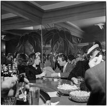Champagne Cholly Book Party [Man and woman talking at the bar.]