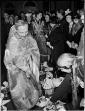[Priest blessing baskets of eggs.]