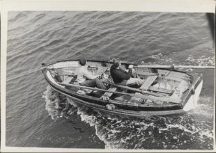 [Crew members rowing boat.]