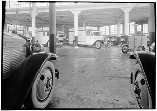 Rex Cole garage. Looking out on floor from between two trucks.