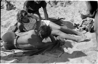 [Teenagers relaxing on Coney Island beach.]