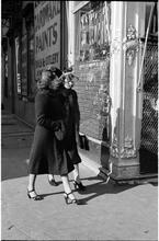 [Two women walking on sidewalk.]