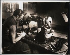 Interior, shoe factory with man at machine
