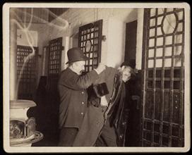 [Well-dressed man being thrown into jail.]