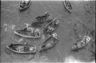 [Overhead view of men in rowboats.]