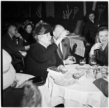 Champagne Cholly Book Party [People socializing at a table.]