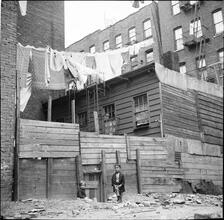 Little Girl near Rear Wooden Tenements
