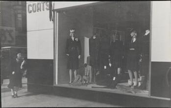 [Women's clothing displayed in store window.]
