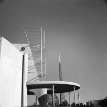 [Construction of the New York World's Fair site. Production and Distribution building, with the frames of the Trylon and Perisphere in the background.]