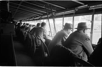 Football Writers [Reporters commentating on a football game in a stadium from the press box.]