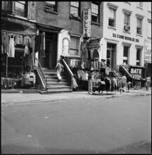 [Clothes for sale in front of 104-106 Rivington Street.]