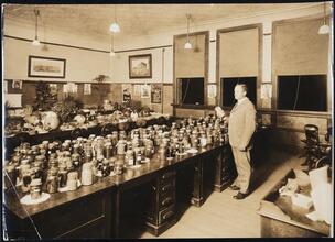 [Food exhibit, man at tables with preserves.]