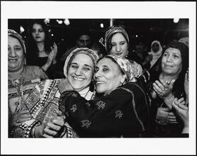 [Women hugging and clapping at a Palestinian wedding at Widdi's Catering Hall.]