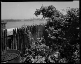 [View from a yard with the Hell Gate Bridge in the background.]
