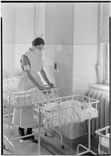 Beth Israel Hospital, Stuyvesant Square. Nurse feeding infant.