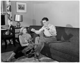 Fashion Models: Lisa Fonssagrives [Meg Mundy and unidentified man playing with dogs at home.]
