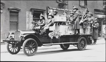 [Firemen on a fire engine.]
