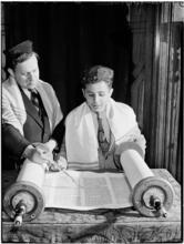 [Boy reading a Torah scroll.]