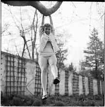 Betsy Von Furstenberg [Swinging from a tree branch.]