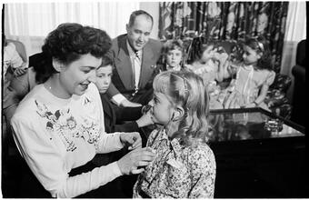 Deaf Children [Teacher helping child with her hearing aid.]