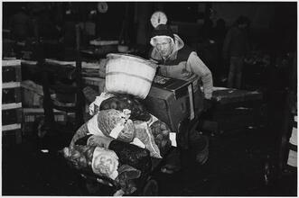 [Man pushing cart of food.]